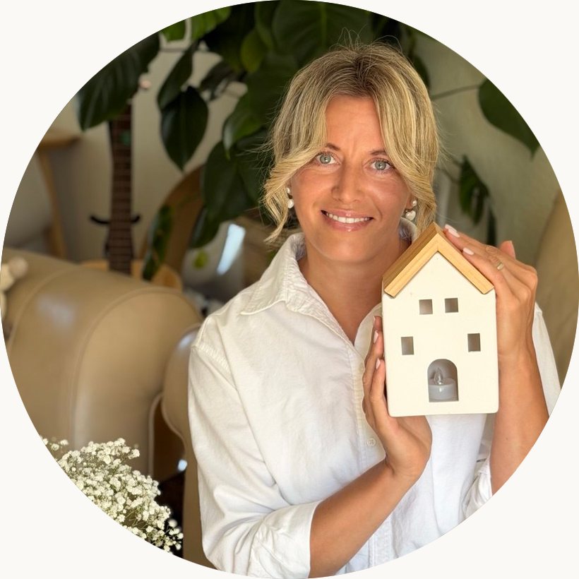 The cleaner behind White as Snow Cleaning, smiling and holding a small model house